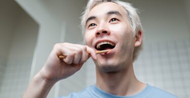 man brushing his teeth