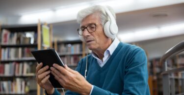 an elderly man watching on a digital tablet