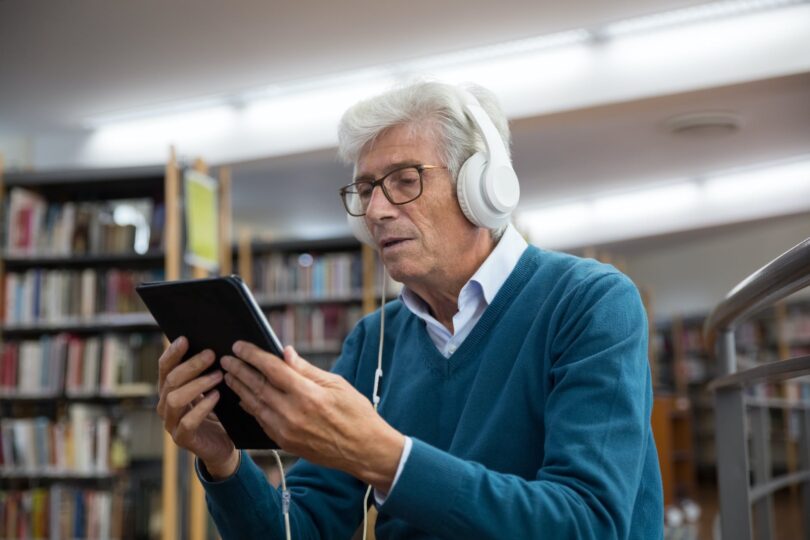 an elderly man watching on a digital tablet