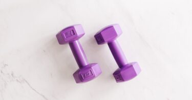 purple all cast dumbbells on marble surface