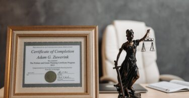 a certificate and lady justice figurine on table