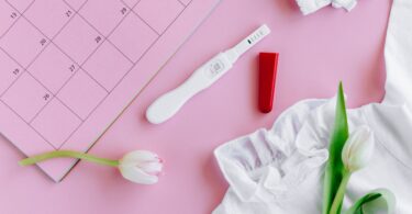 white pregnancy test kit beside white shirt