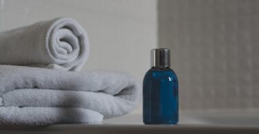 blue glass bottle beside white towel
