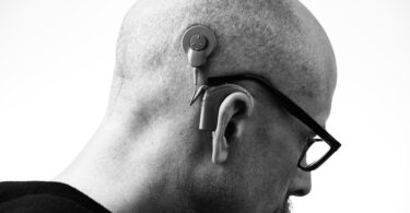 grayscale photo of a man with a hearing aid