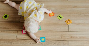 a toddler playing with puzzle pieces on the floor
