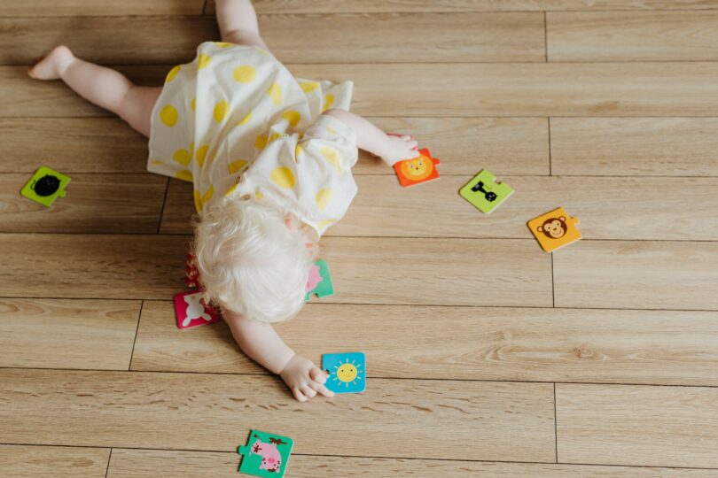 a toddler playing with puzzle pieces on the floor