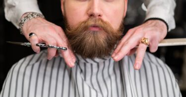man in white and gray pinstripe having a haircut