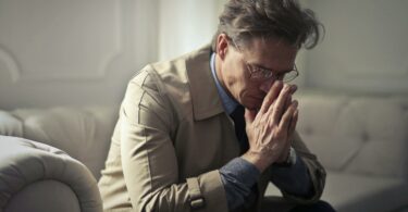 sad mature businessman thinking about problems in living room