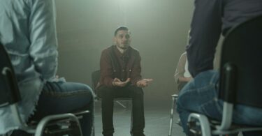 man in black blazer sitting on chair