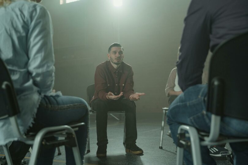 man in black blazer sitting on chair