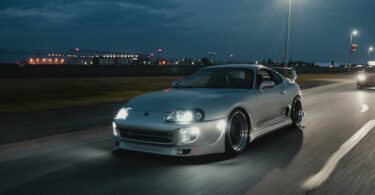 silver car driving on the road at night