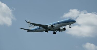 klm airplane descending over hamburg sky
