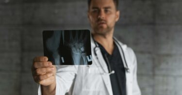 man in white button up shirt holding black android smartphone