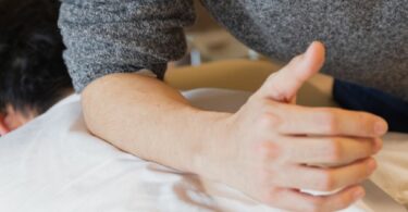 man doing massage to patient lying on couch