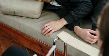 man in black jacket lying on couch